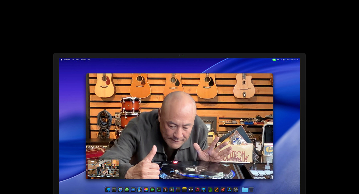 Докато води видеоразговор, човек в музикален магазин разглежда отблизо грамофон, но остава центриран в кадър, благодарение на камерата Center Stage