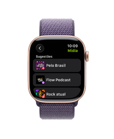 Apple Watch Series 11 com caixa de alumínio cor de ouro rosa, pulseira loop esportiva roxo-névoa e Digital Crown na lateral direita. A tela mostra sugestões de músicas e podcasts no Apple Music