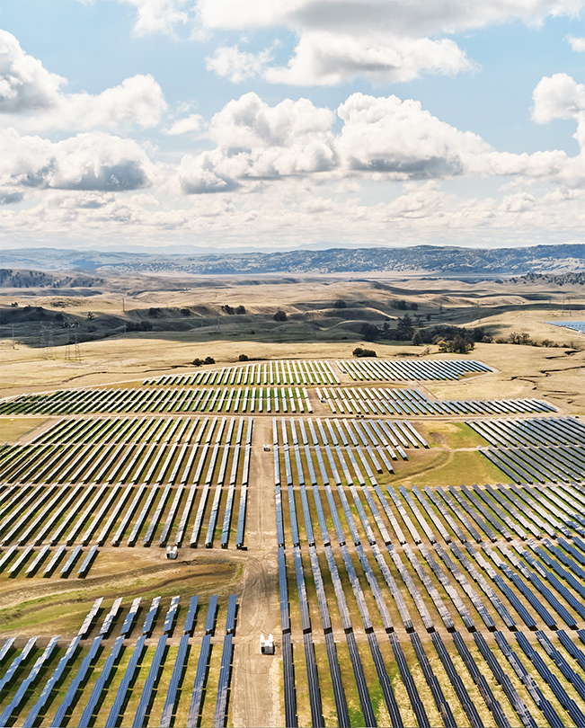 Luftaufnahme einer großen Fläche mit zahlreichen Solarpanelen zur Energieerzeugung.