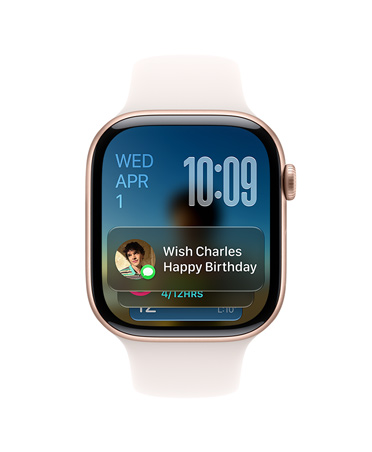 Růžově zlaté Apple Watch Series 11 se světle ruměným řemínkem, v levém horním rohu ciferníku se zobrazuje datum, vpravo nahoře čas a dole widget Zprávy