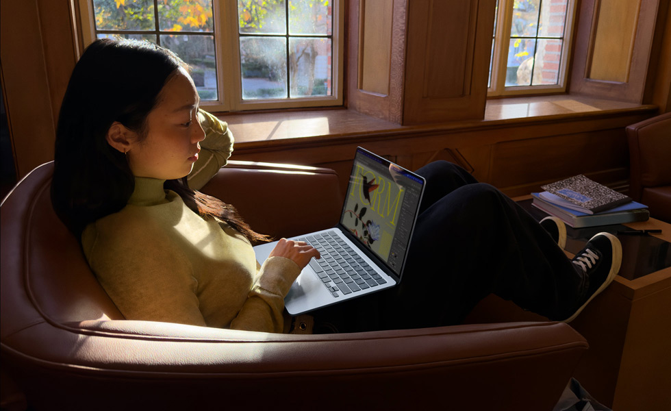 Eine Person auf einem Stuhl arbeitet mit einem MacBook Air