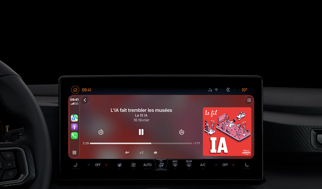 Intérieur d’une voiture, l’écran de la console centrale affiche Apple Podcasts en cours d’utilisation via CarPlay, le podcast "The Spark of Life" de Radiolab est en cours de lecture, les commandes de lecture comprennent le retour en arrière, la mise en pause et le saut en avant.
