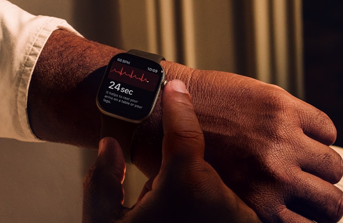 Valaki hosszan benyomja a Digital Crownt az Apple Watch Series 11-en, hogy az EKG appal felmérje a szíve egészségét