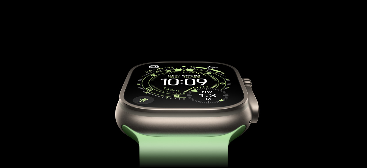 Apple Watch Ultra 3 natúr titántokkal és élénk neonzöld Óceán szíjjal, a kijelzőn az iránytű és a Tájékozódás számlap jelenik meg.