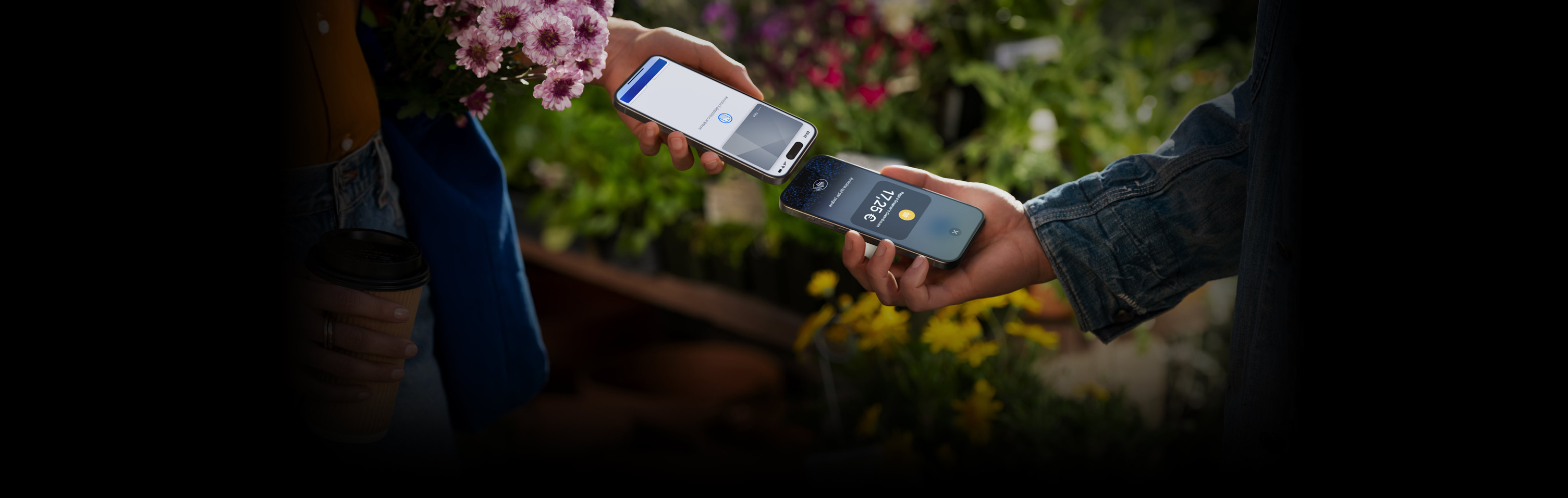 Due persone che avvicinano i propri iPhone per completare una transazione.