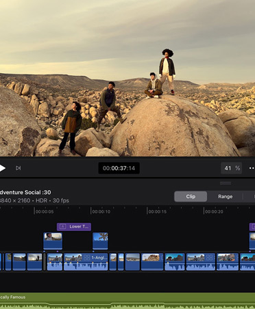 Un’app di editing video con l’immagine di alcune persone in posa su delle rocce in un paesaggio montagnoso e desertico, la timeline e gli strumenti di modifica