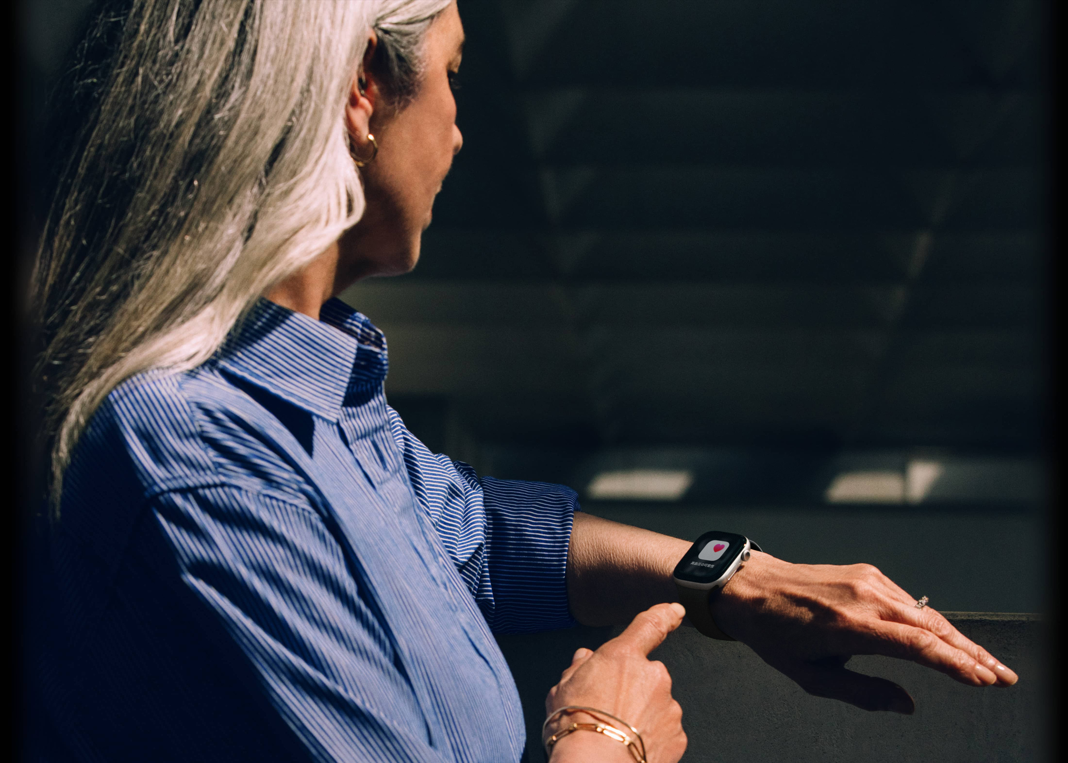 人物がApple Watch Series 11で高血圧パターンの通知を読んでいる