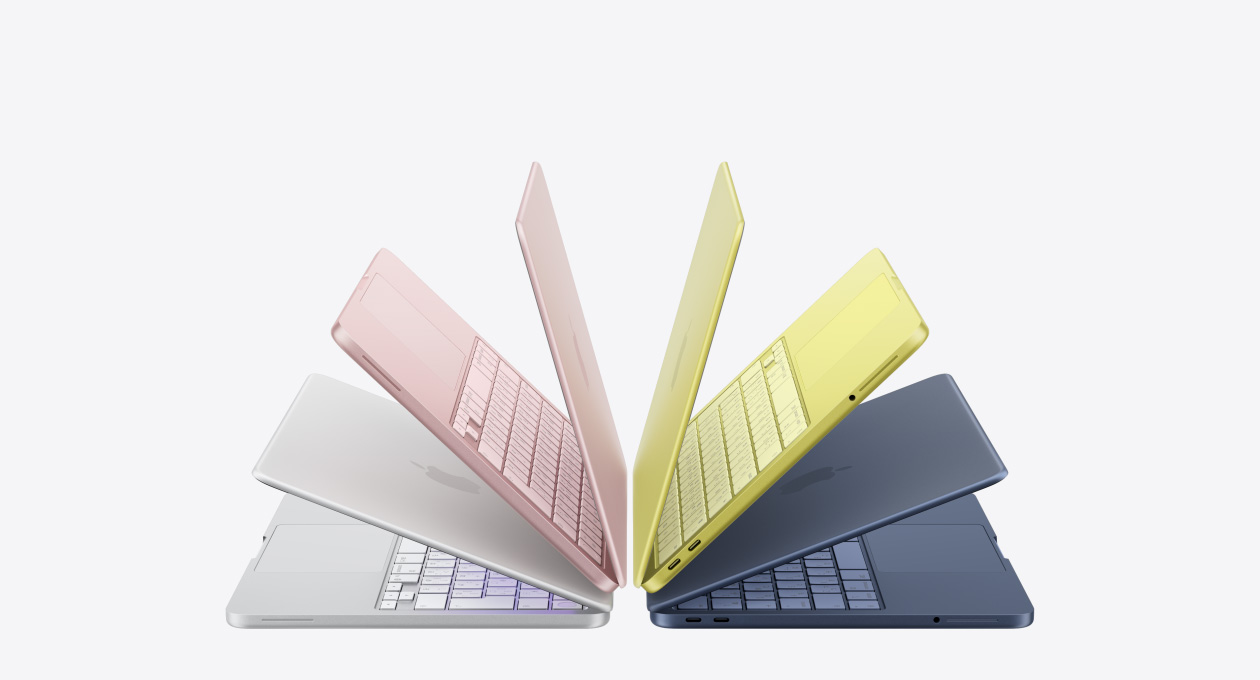 わずかに開いた状態でアーチ状に並べられたシルバー、ブラッシュ、シトラス、インディゴのMacBook Neoノートブック