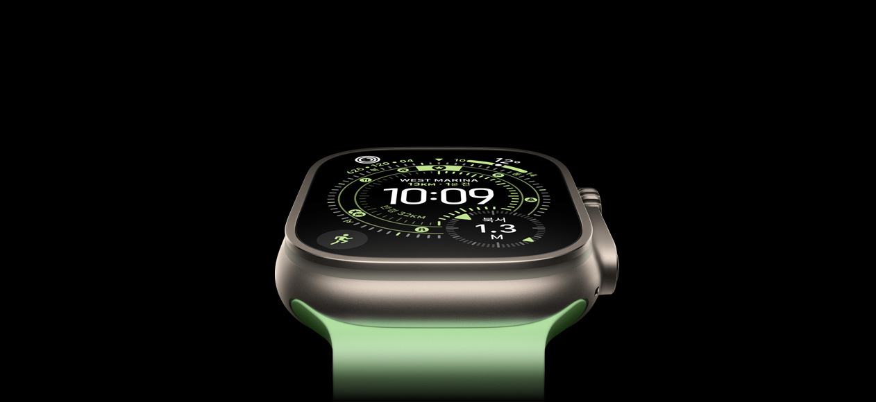 네온 그린 오션 밴드가 장착된 내추럴 티타늄 케이스 Apple Watch Ultra 3의 대표 하드웨어 이미지. 나침반이 표시된 오리엔티어링 시계 페이스를 보여주고 있습니다.