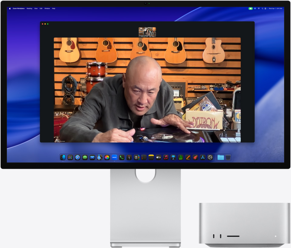 În timp ce se află într-un apel video pe Studio Display XDR cu un Mac Studio așezat dedesubt, o persoană dintr-un magazin de muzică privește de aproape un pickup