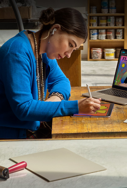 Student at a desk drawing on iPad with Apple Pencil
